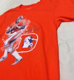 ジョン・エルウェイ  デンバー ブロンコス ファナティックス レジェンド イラストレーション Tシャツ (オレンジ)/ John Elway Denver Broncos